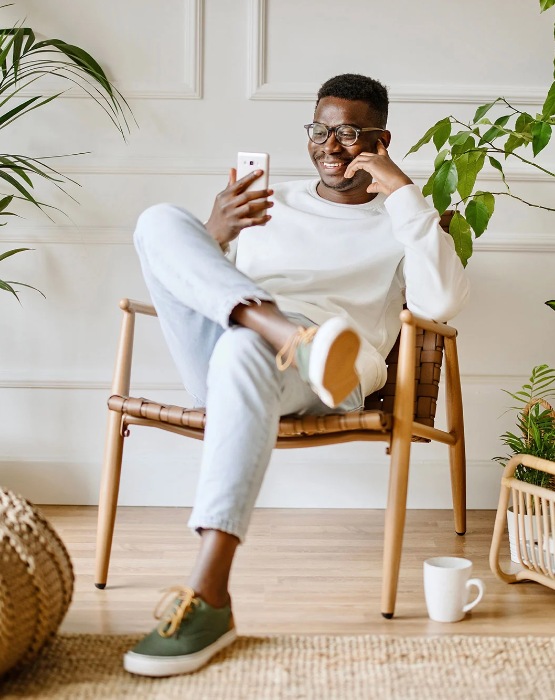 man sitting in a chair viewing mobile phone
