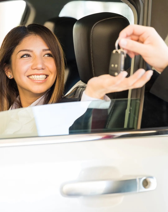 a lady being handed keys to her new automobile
