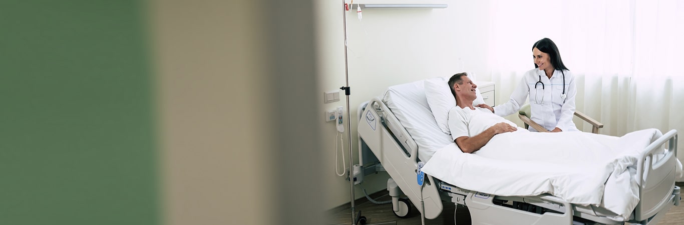 a patient laying in bed talking to a doctor