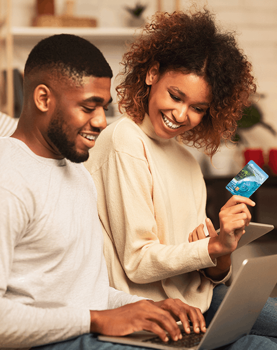 Couple looking at laptop, woman holding a credit card