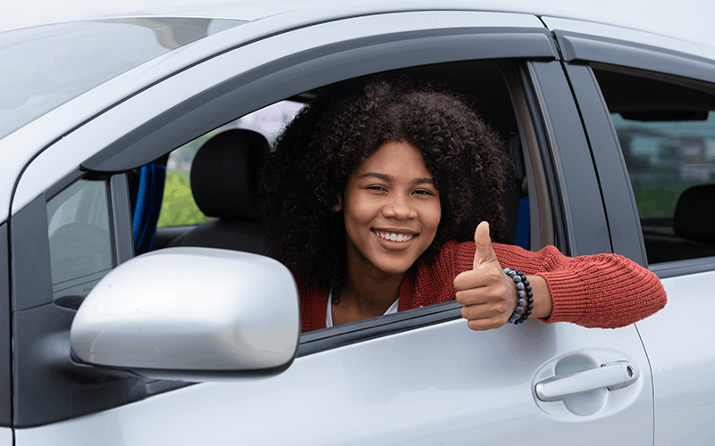 Woman driver giving the thumbs up.