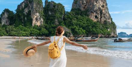 Young woman on vacation watching the boaters on the beach