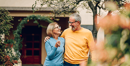 Senior couple standing outside their beautiful home