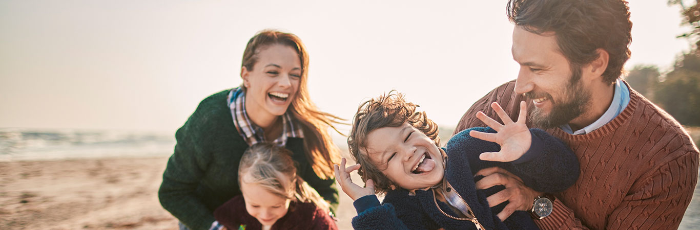 a family of four playing at the beach