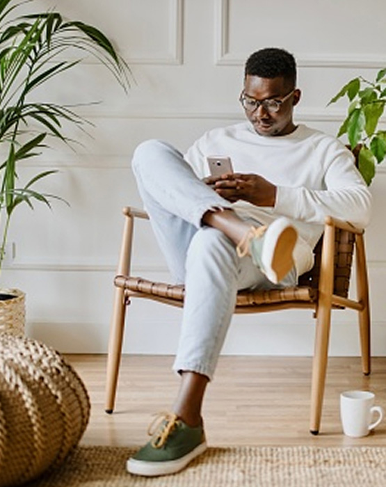 man sitting in a chair looking at his mobile phone