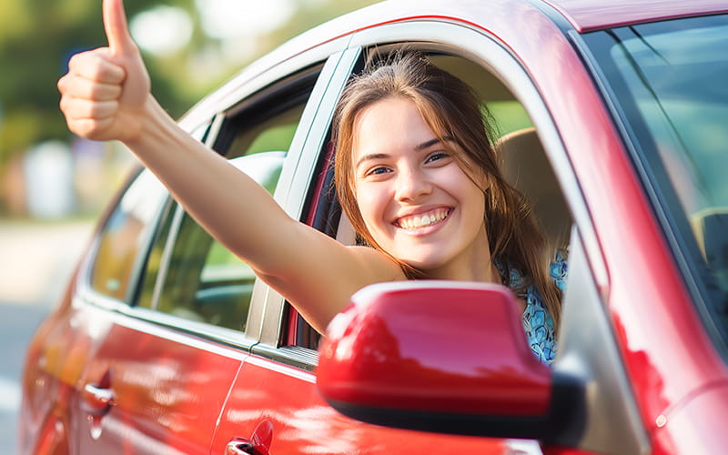 Woman giving the thumbs-up while in the car