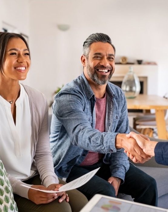a couple shaking hands with a banker