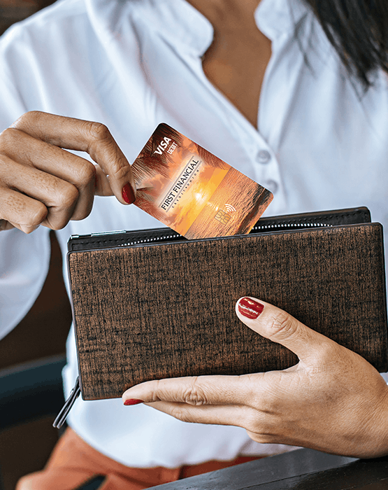 woman putting debit card inside wallet