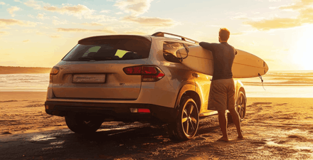 Man holding surboard standing next to white SUV