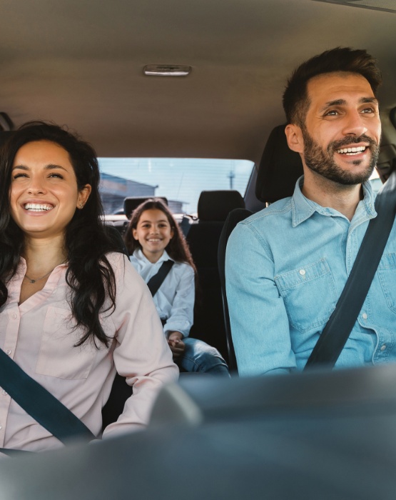 a family of three riding in a vehicle
