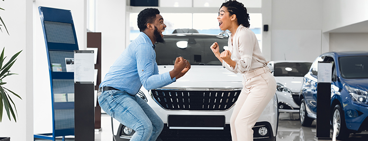 Couple celebrating their joyful auto-buying experience.